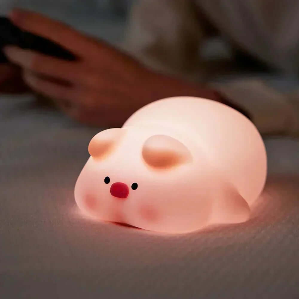 Pig-shaped silicone night light providing soft glow for kids' rooms.