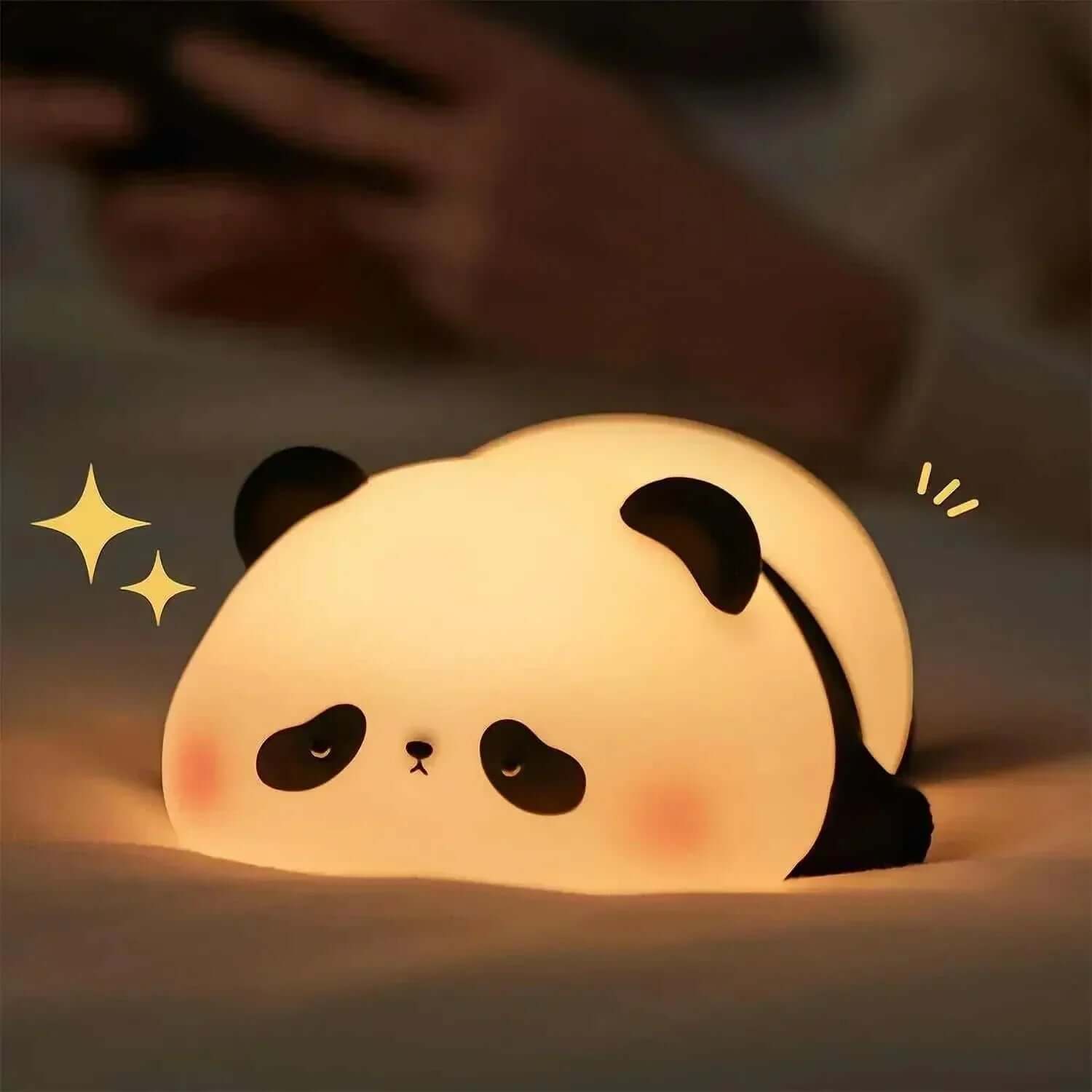 Panda-shaped night light with soft glow from 'The Panda Night Light Collection' on a bed.